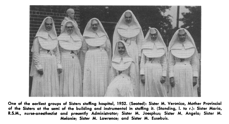 A group of 7 white-habited nuns, the Sisters of Mercy staffing the hospital, pictured in 1952. The seated nun in the center is said to be Sister M. Veronica. 